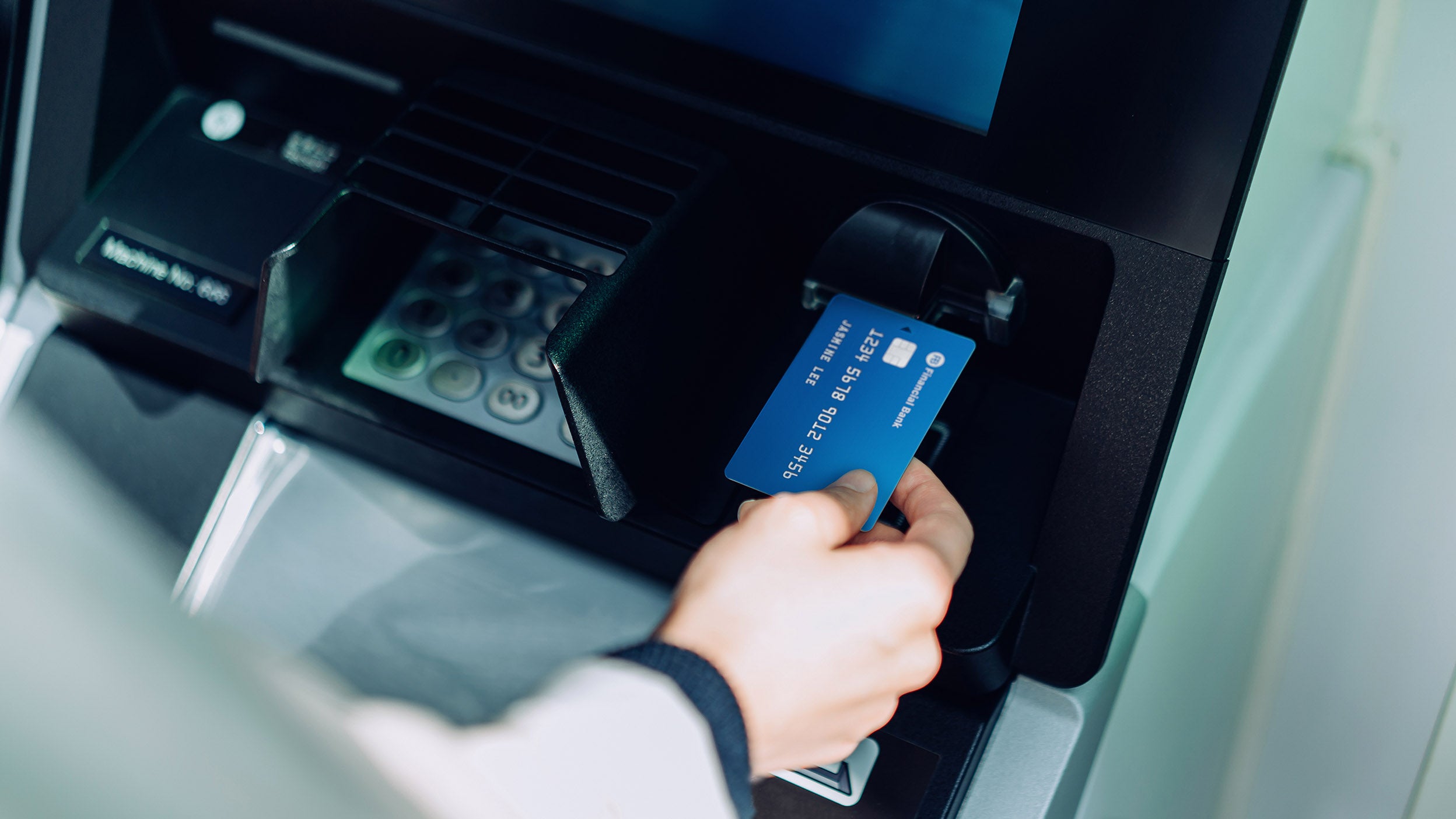 Person inserting his debit card in ATM