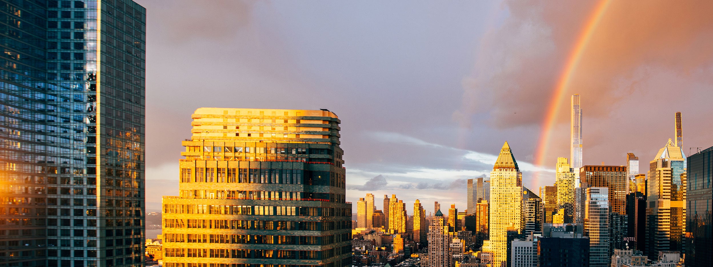 Regenbogen über der Skyline der Stadt bei Sonnenuntergang.