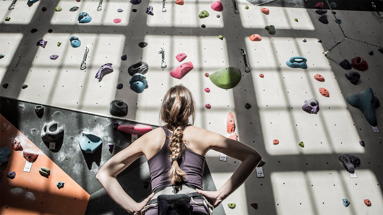 Athlete examining rock wall in gym