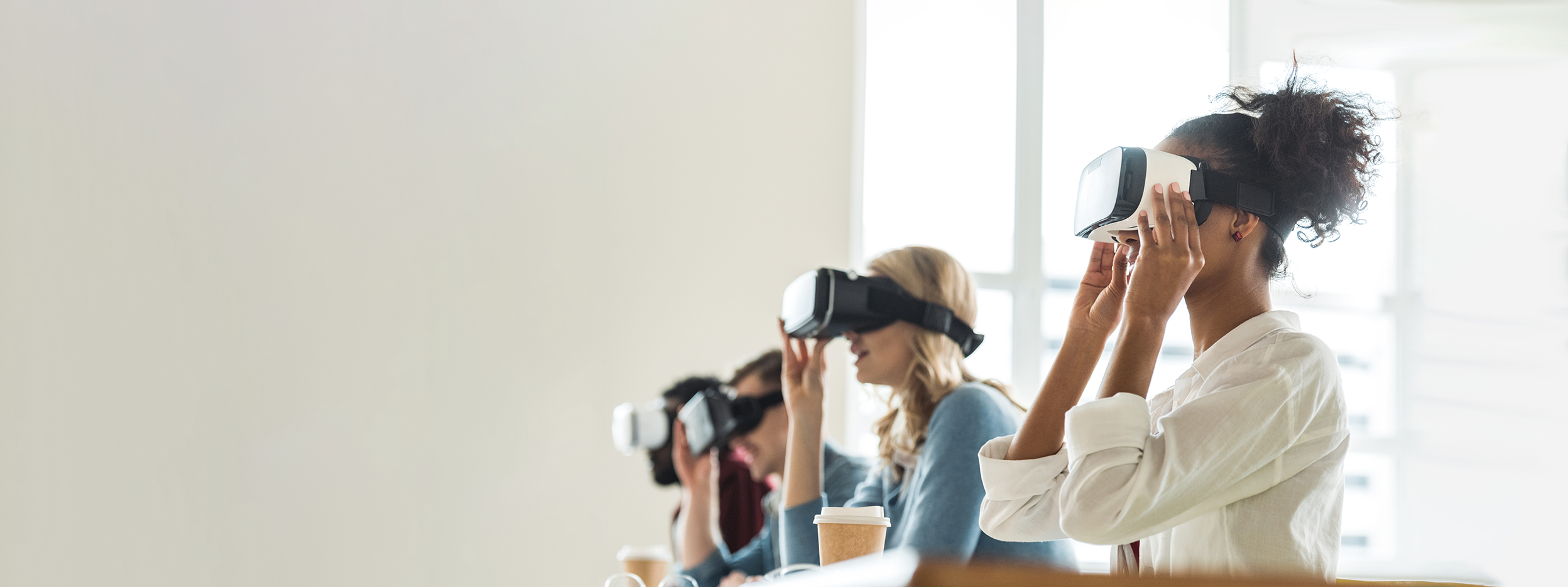 People seated in a row wearing VR headsets.