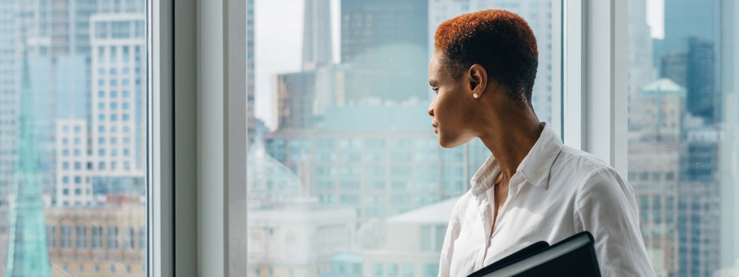 Woman looking through glass window from building