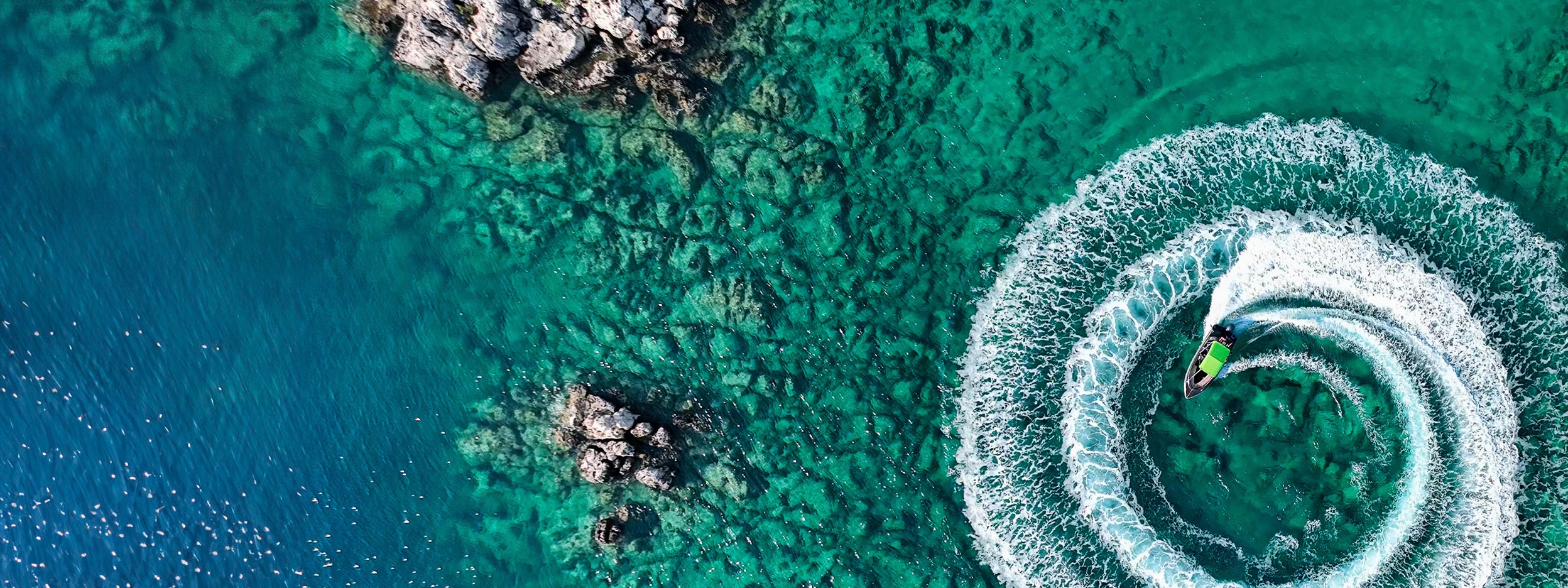 View from above of jet ski driving in circles in the ocean 