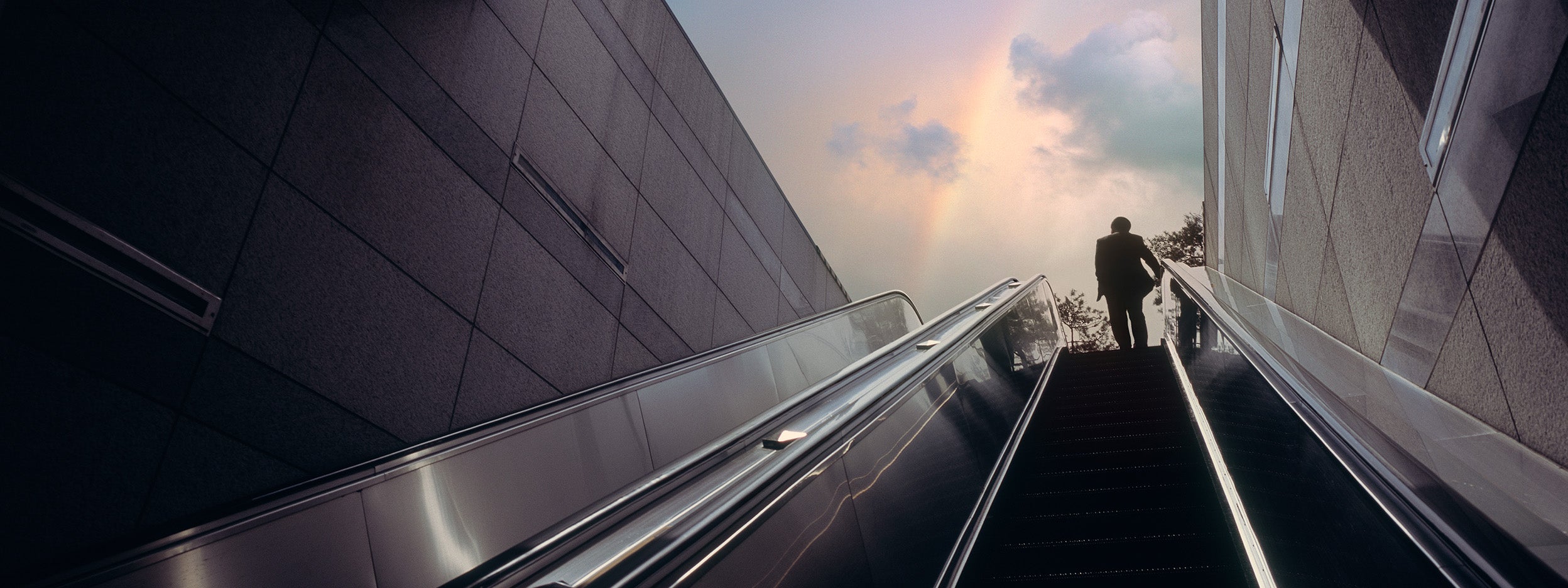 Man standing on ascending escalator