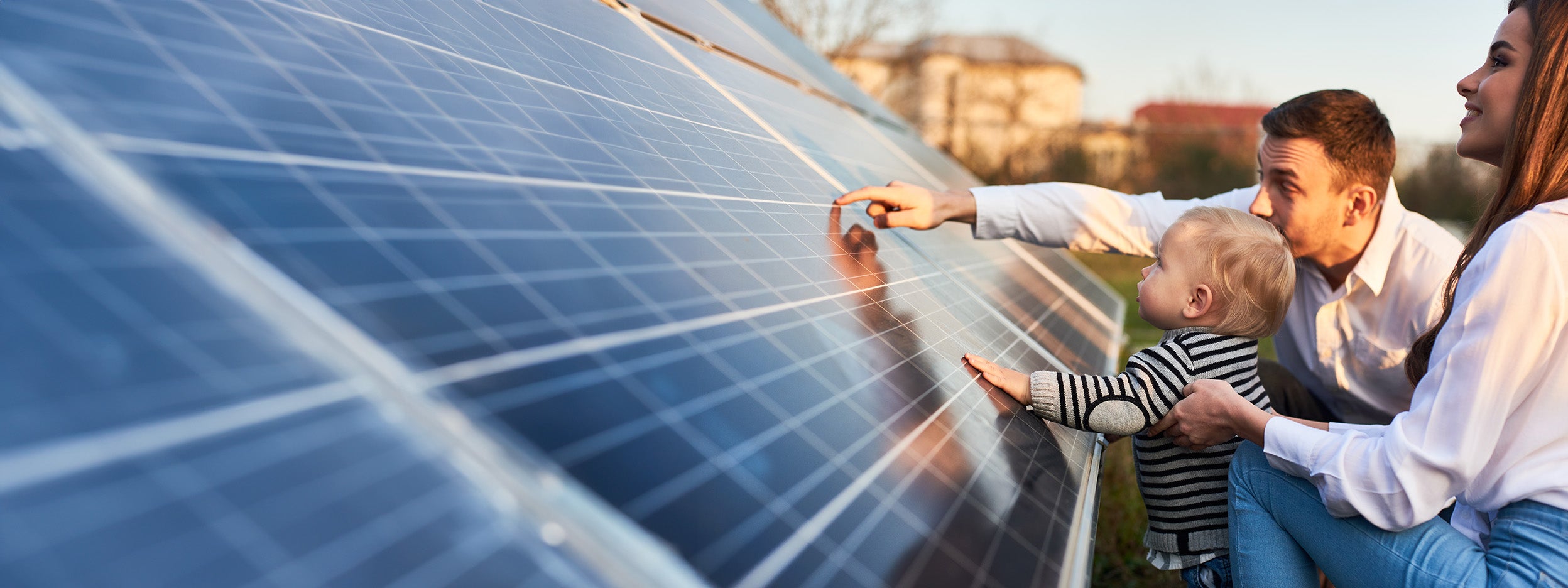 Man and woman and child looking at solar panel