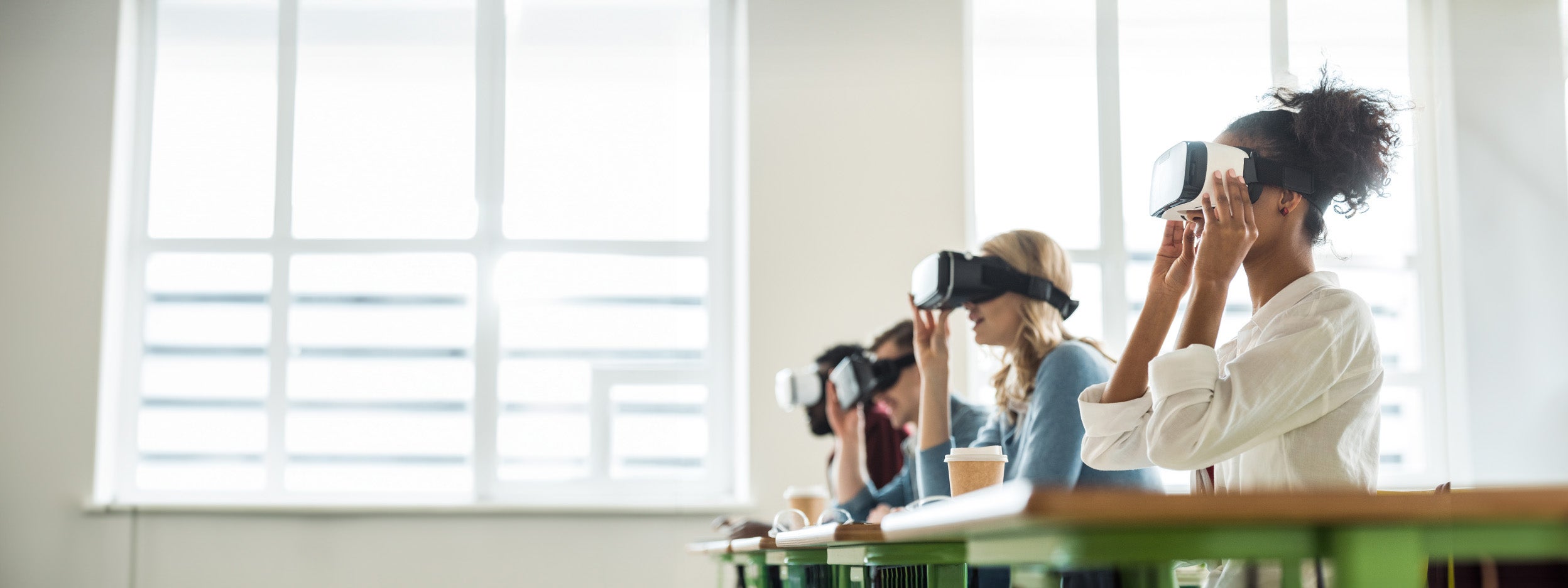 A group of four people looking through VR headsets