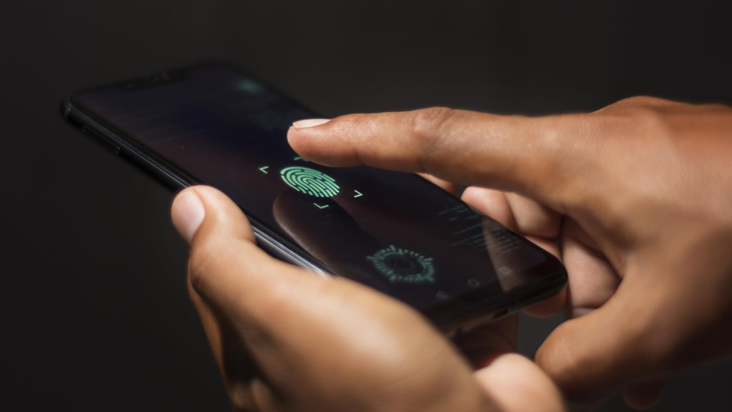 Person verifying identity on mobile device through fingerprint