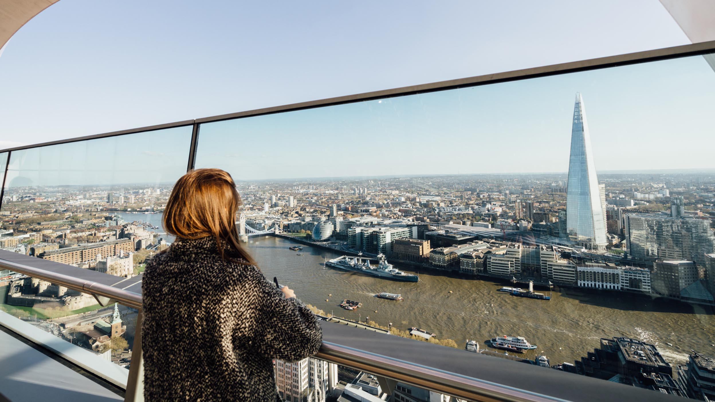 women looking at river through glass