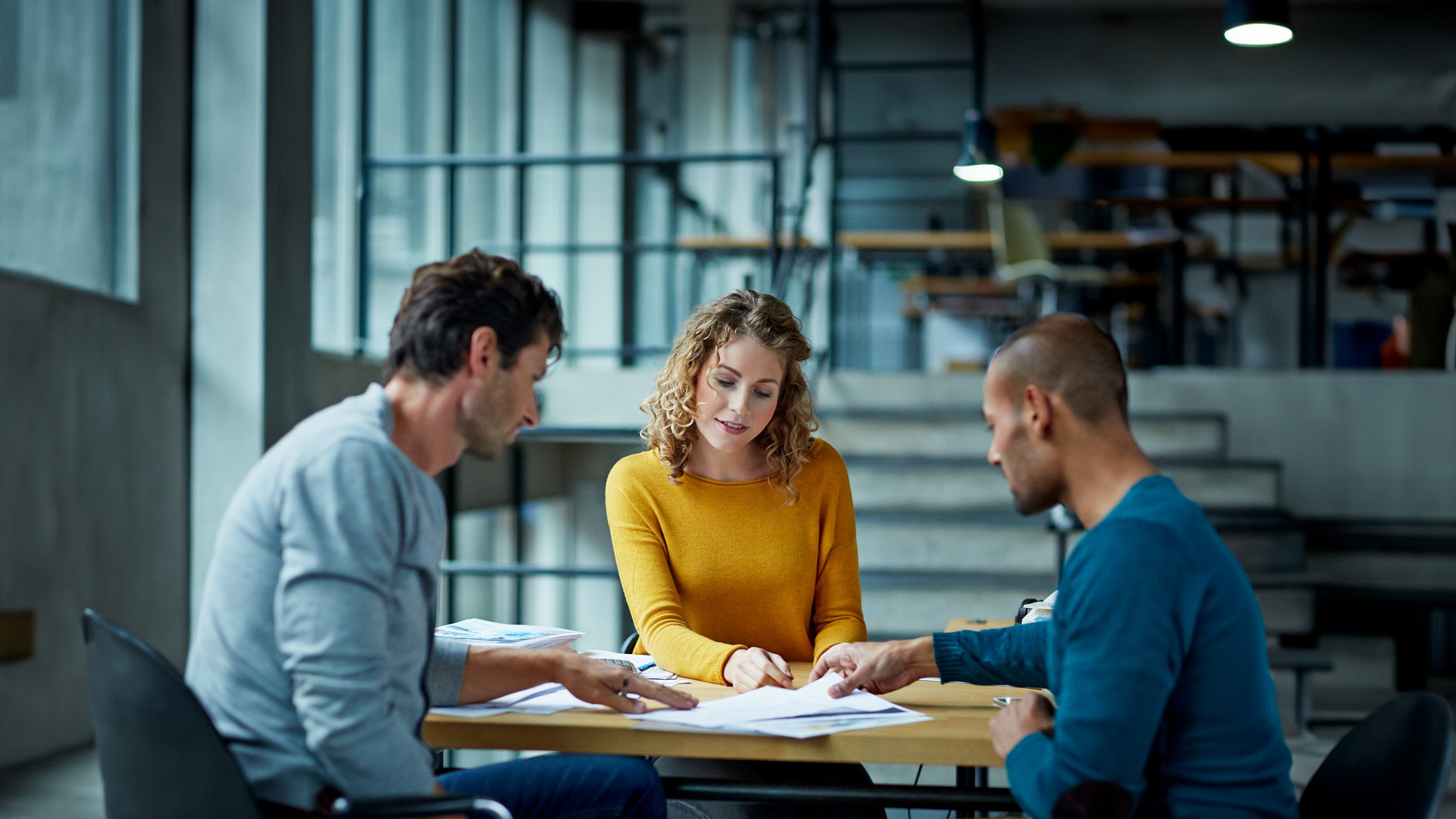 Three employees discussing in office