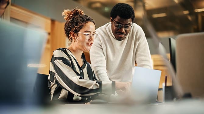 Women showing something in her laptop to a colleague