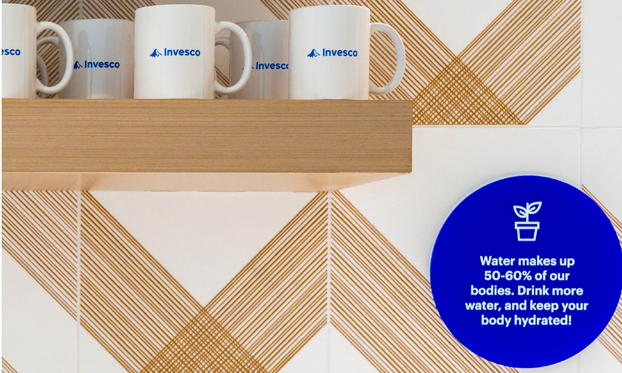 Office kitchen with reusable mugs and educational signage