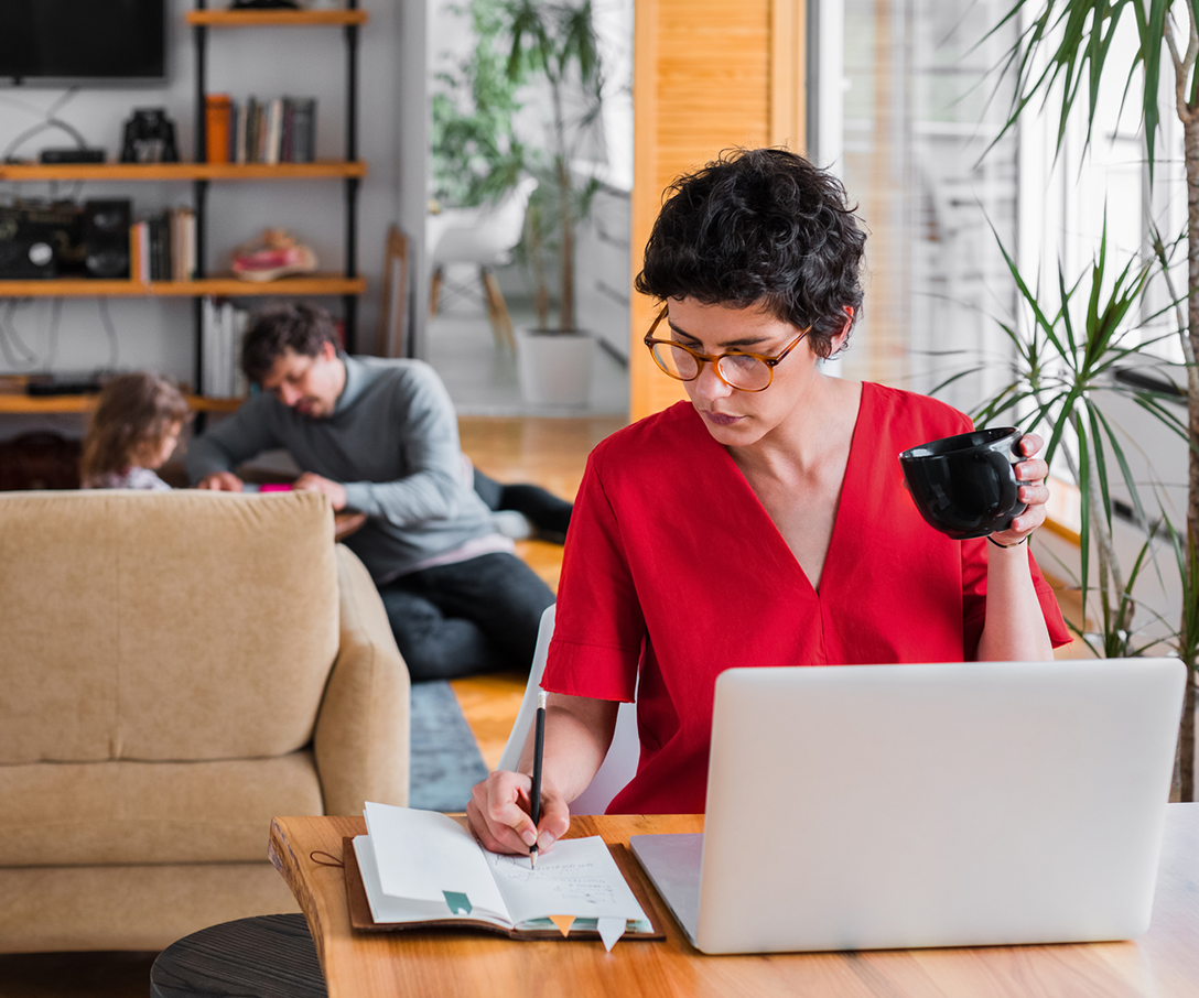 Woman studying and writing on a laptop