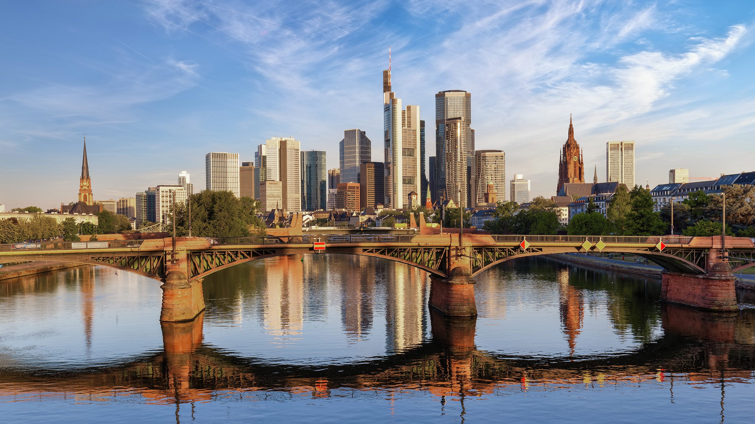 Sonnenaufgang über der modernen Skyline von Frankfurt am Main, Deutschland, mit goldenem Sonnenlicht, das auf die Bürohochhäuser der Stadt scheint.