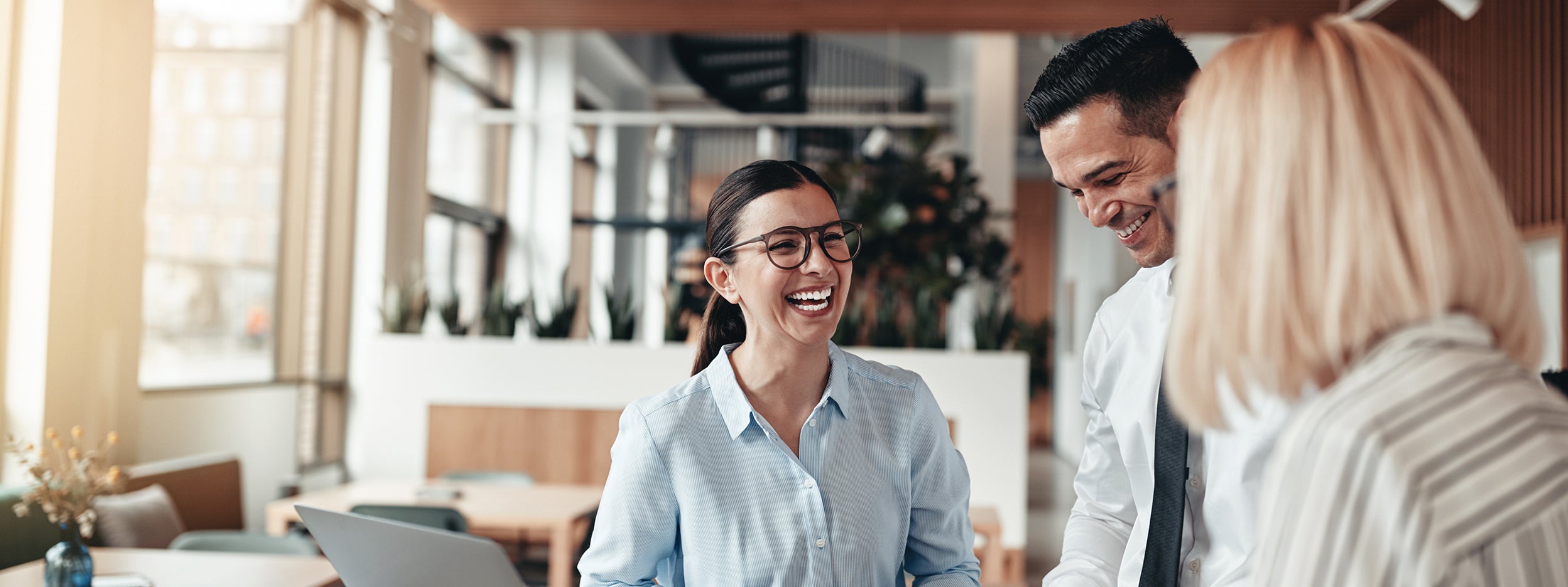 Three people stand next to each other and having a laugh
