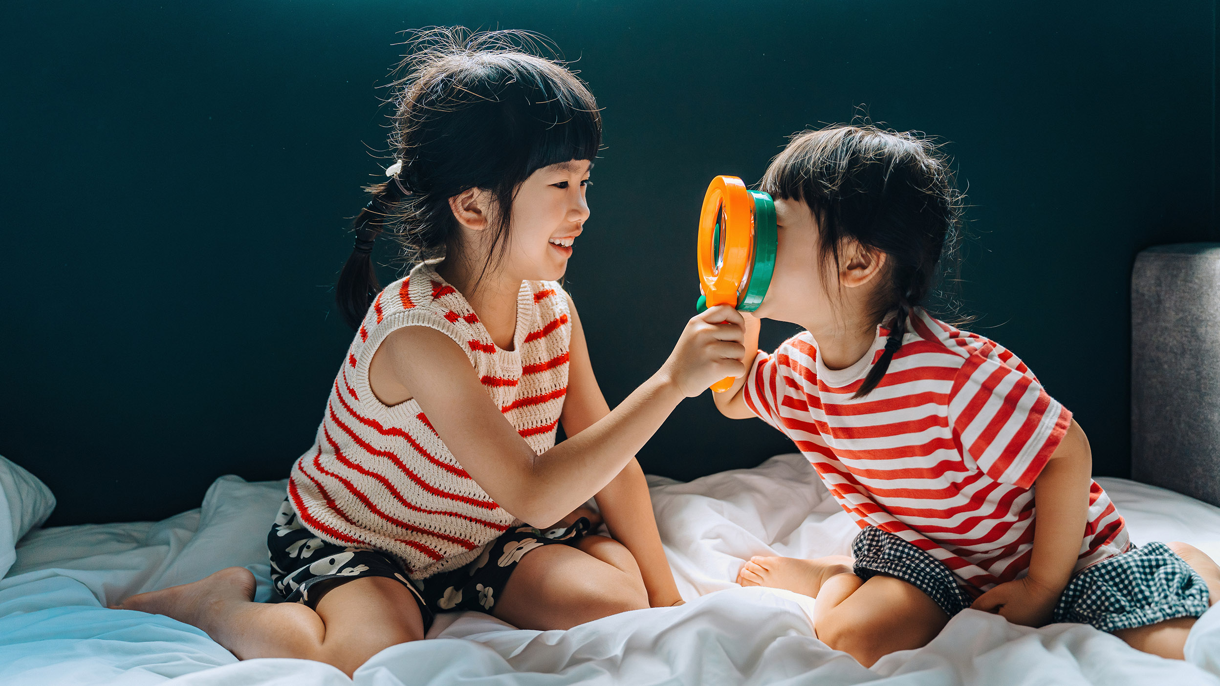 Two young girls playing with magnifying glasses.