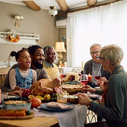 Happy%20extended%20family%20having%20fun%20while%20gathering%20at%20dining%20table%20on%20Thanksgiving.