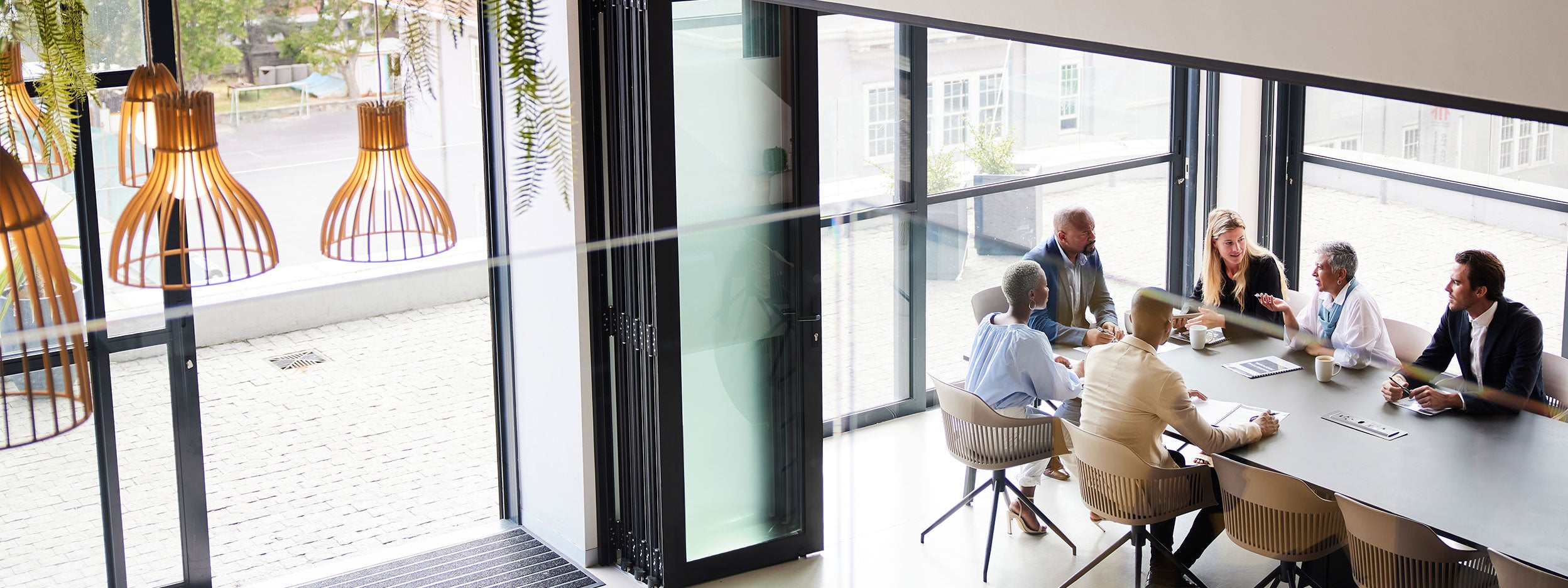 High angle view of a diverse group of businesspeople talking together around a conference table during a boardroom meeting in an office.