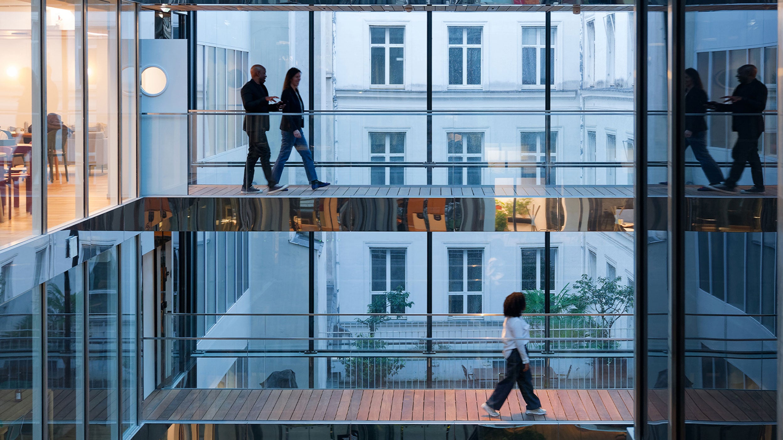 People walking across glass office walkways