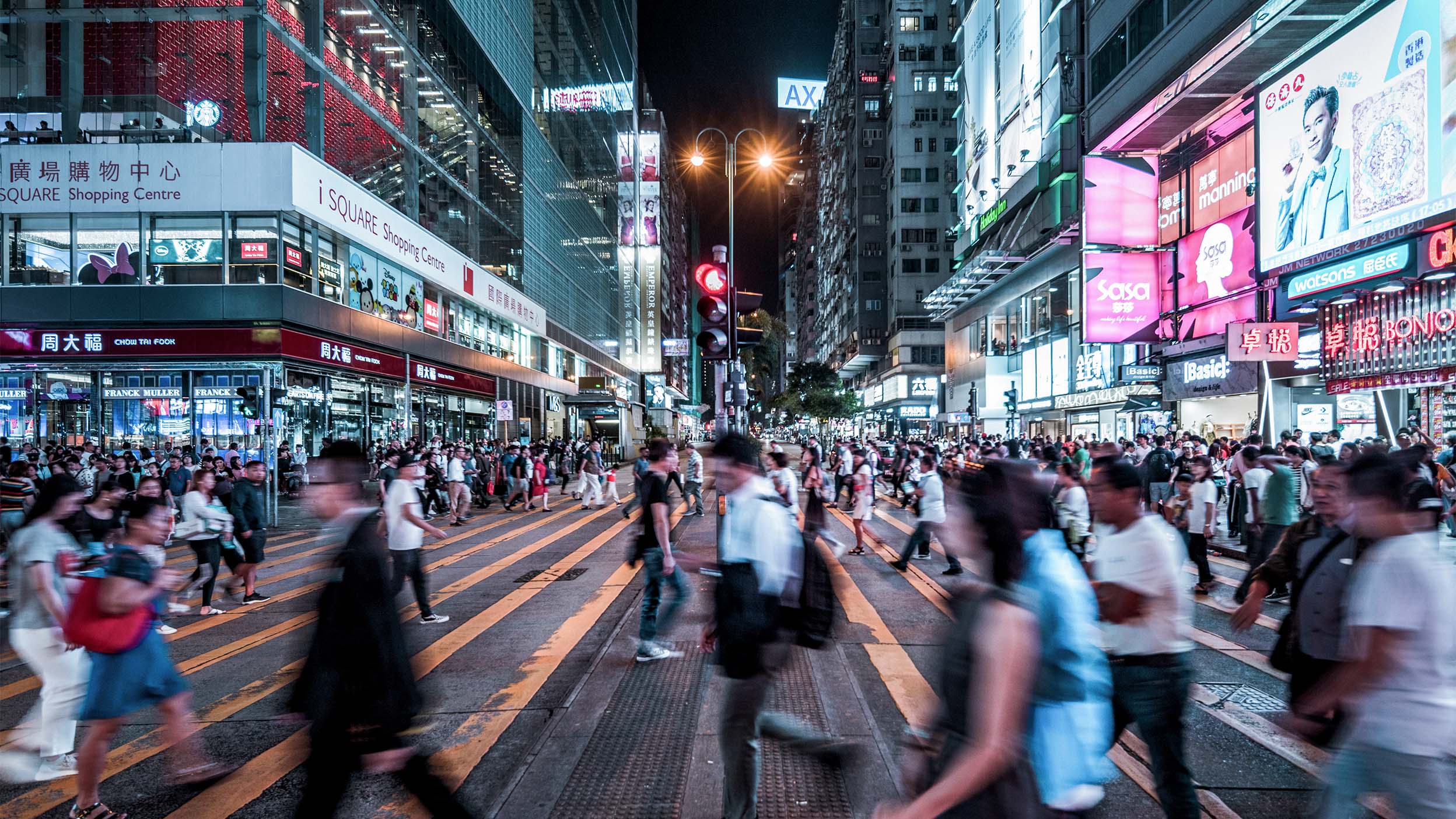 A crowd of people cross a city street in China