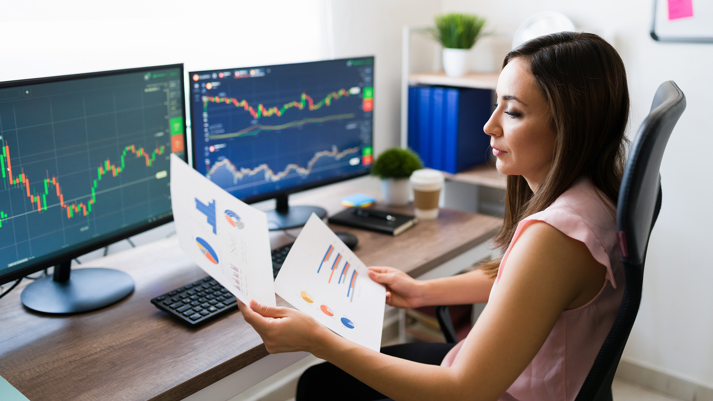 Business analyst looking at a graph chart while working from home as a freelance. Professional young woman buying stocks.
