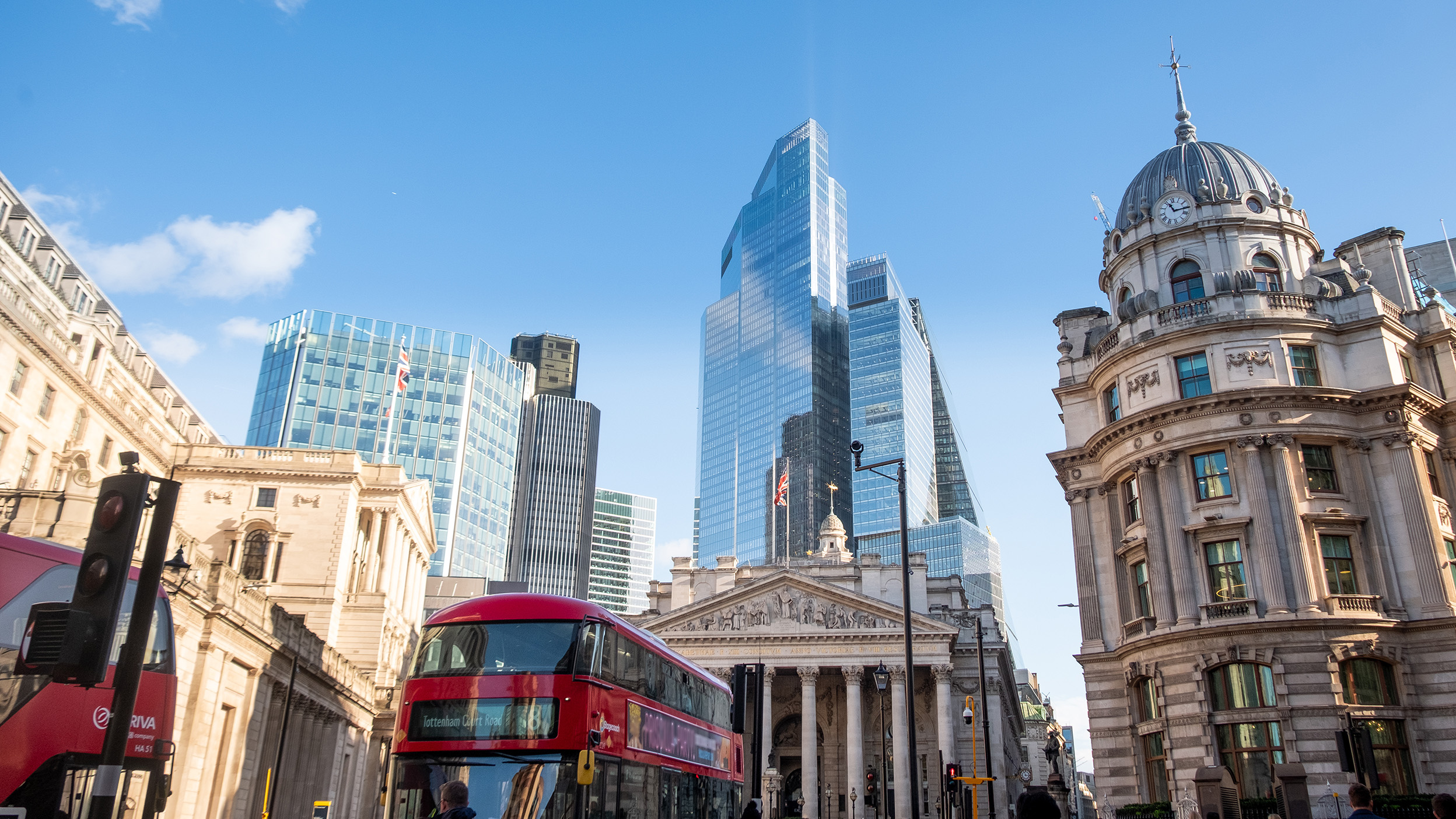 London skyline with modern office towers and a red double-decker bus.