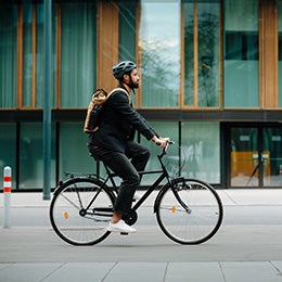 Side%20view%20of%20a%20city%20commuter%20riding%20to%20work%20on%20a%20bicycle.%20Young%20single%20businessman%20traveling%20from%20work%20to%20home%20on%20a%20bike,%20wearing%20a%20backpack%20and%20helmet%20for%20safety.