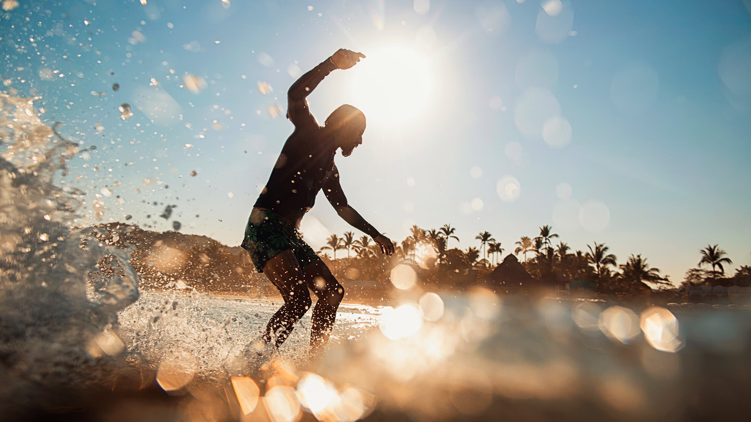 Male surfer riding wave on sunny summer ocean