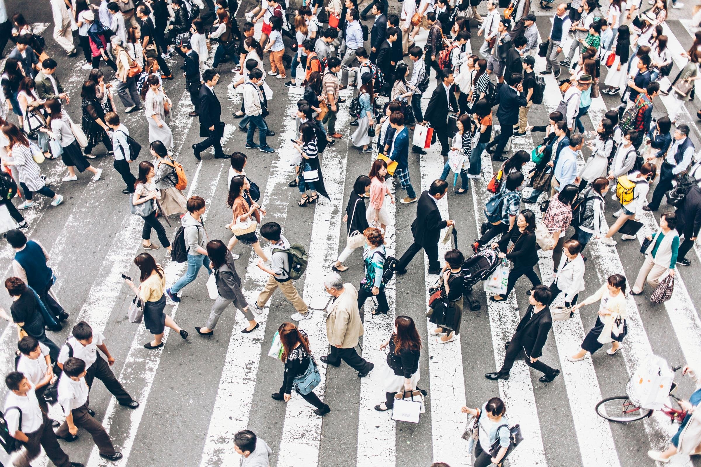 Pedestrians crossing street on walkway in Japan. High angle view.