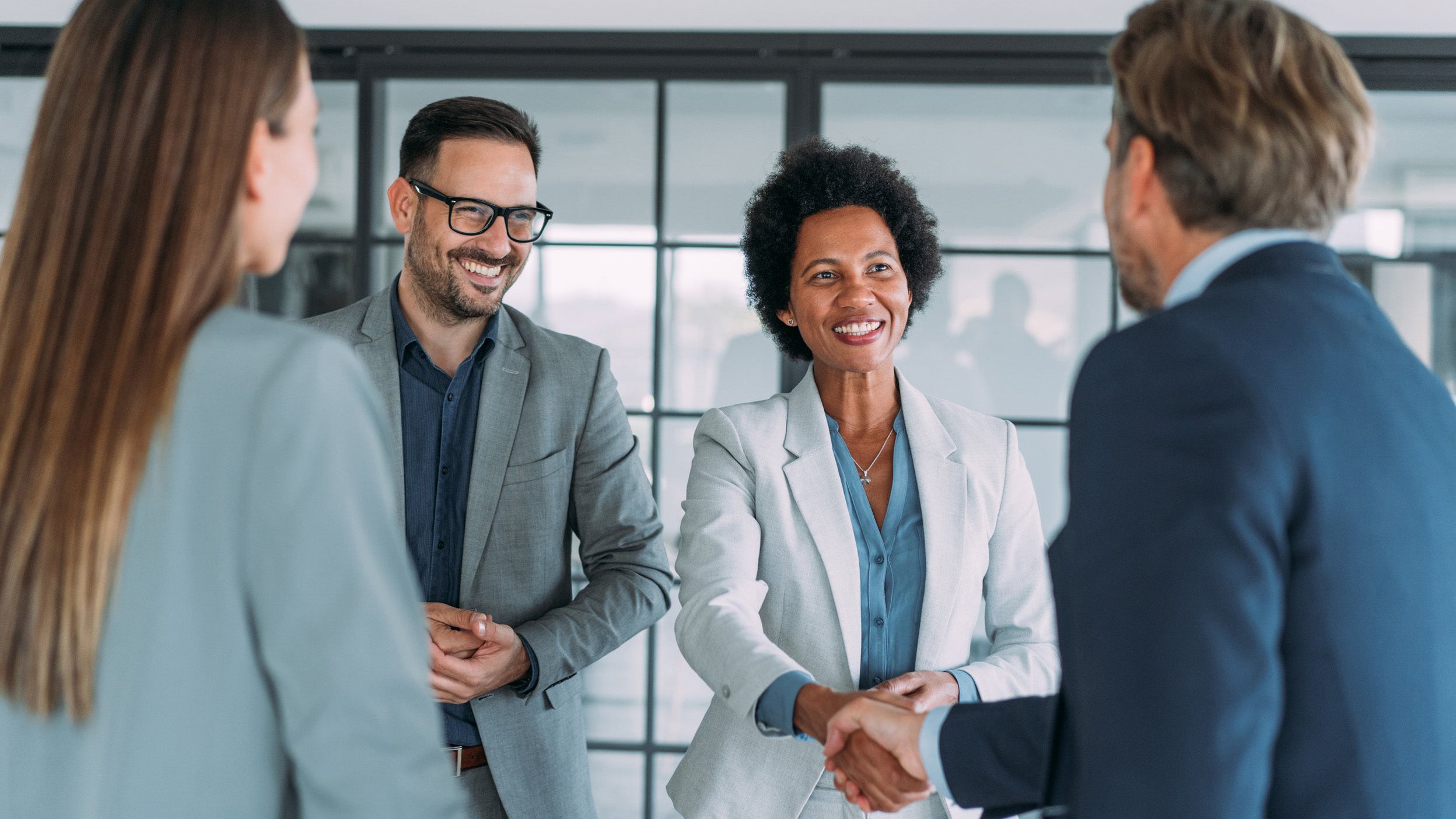 Business people shaking hands in the office. Business persons handshaking during a meeting in modern office.