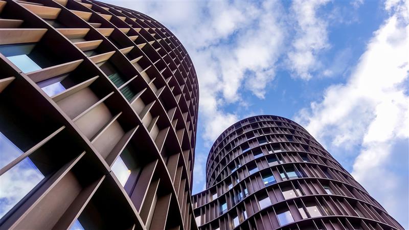 Axel Towers round modern skyscraper office buildings with blue sky and clouds background