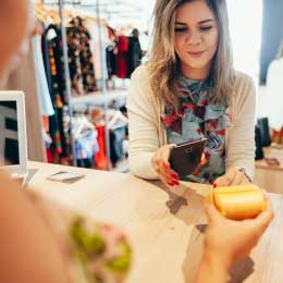 Femme%20payant%20avec%20la%20technologie%20NFC%20sur%20son%20téléphone%20portable,%20au%20restaurant,%20dans%20un%20café,%20dans%20un%20bar,%20dans%20un%20magasin%20de%20vêtements