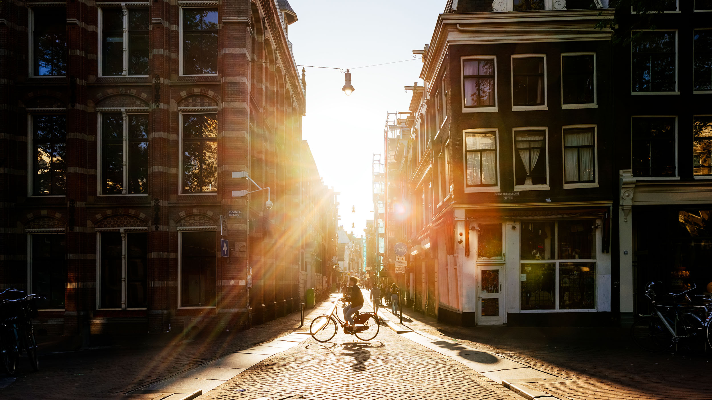 Bike rider on cobblestone street riding through European town.
