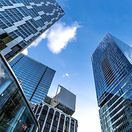 Looking%20up%20at%20modern%20glass%20office%20skyscrapers%20converging%20toward%20a%20bright%20blue%20sky,%20symbolising%20scale,%20structure,%20and%20forward-looking%20institutional%20investment.