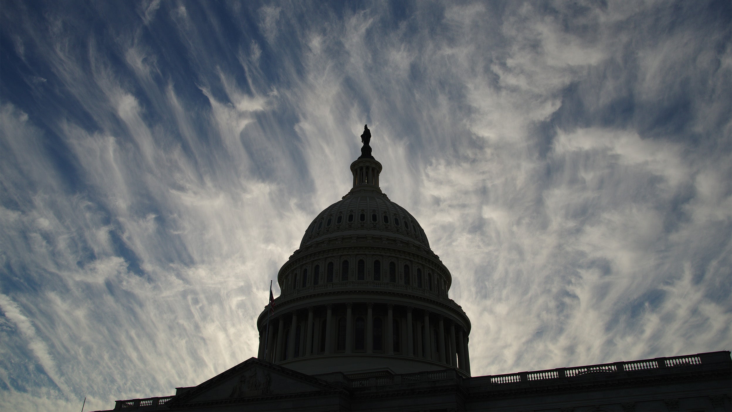 The US Capitol building against a blue, cloudy sky