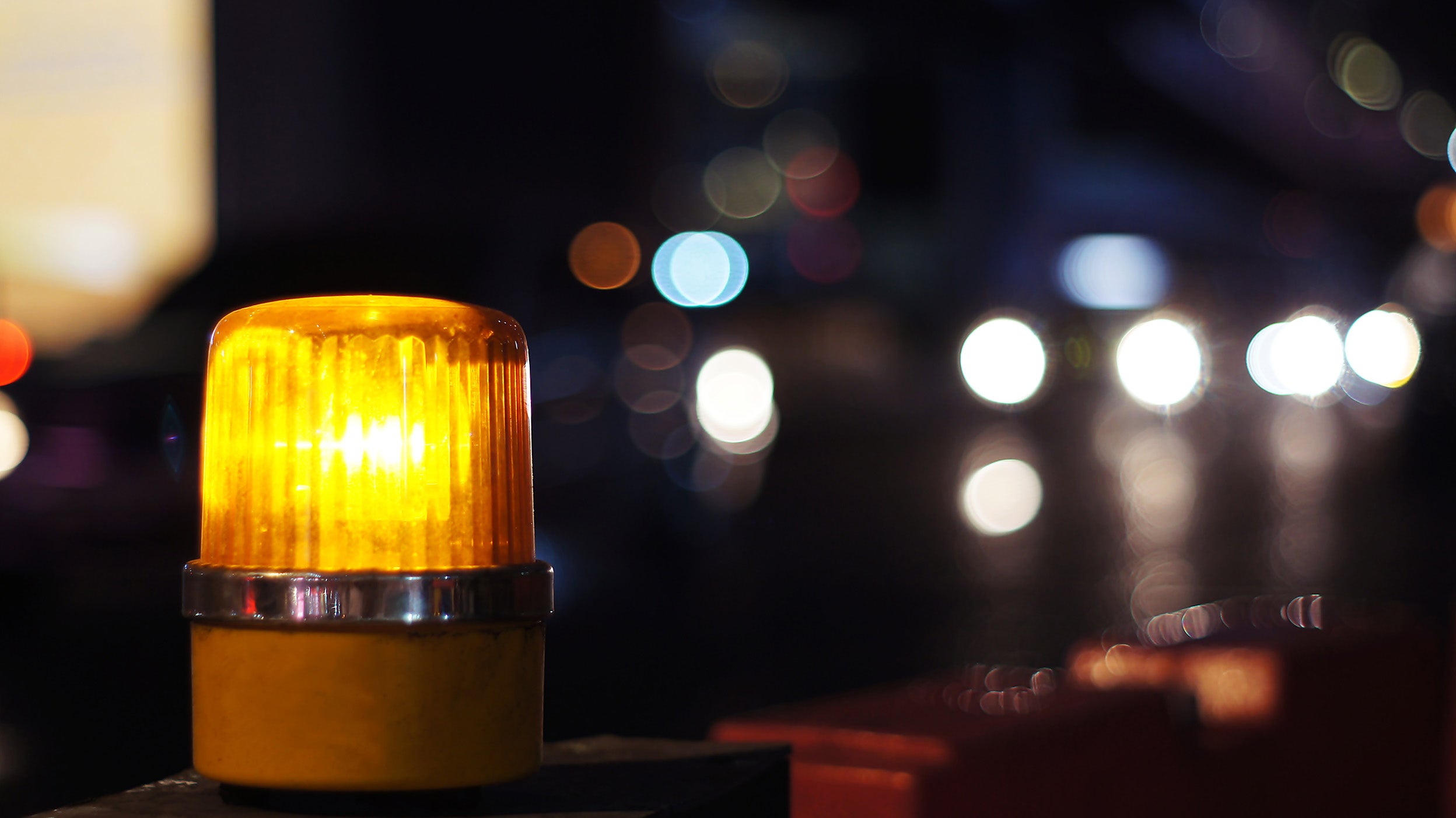 Yellow orange siren light in construction side safety sign, installed beside road
