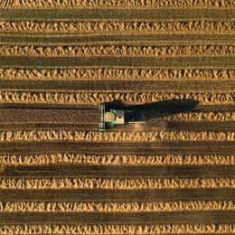 Aerial%20view%20of%20a%20tractor%20working%20in%20a%20vast%20green%20field%20under%20a%20clear%20blue%20sky.