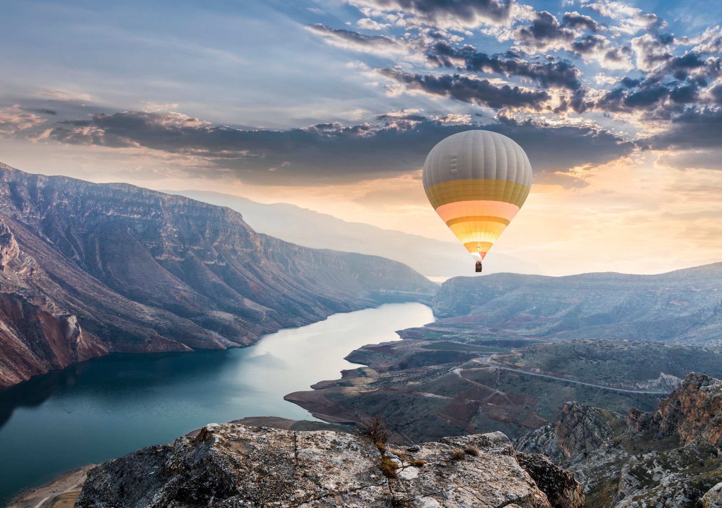 Un mongolfiera vola con un tramonto sullo sfondo