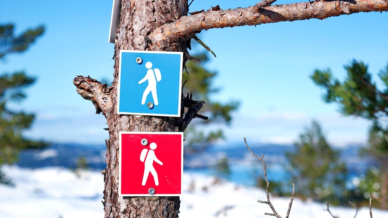 Sign boards of men wearing a backpack