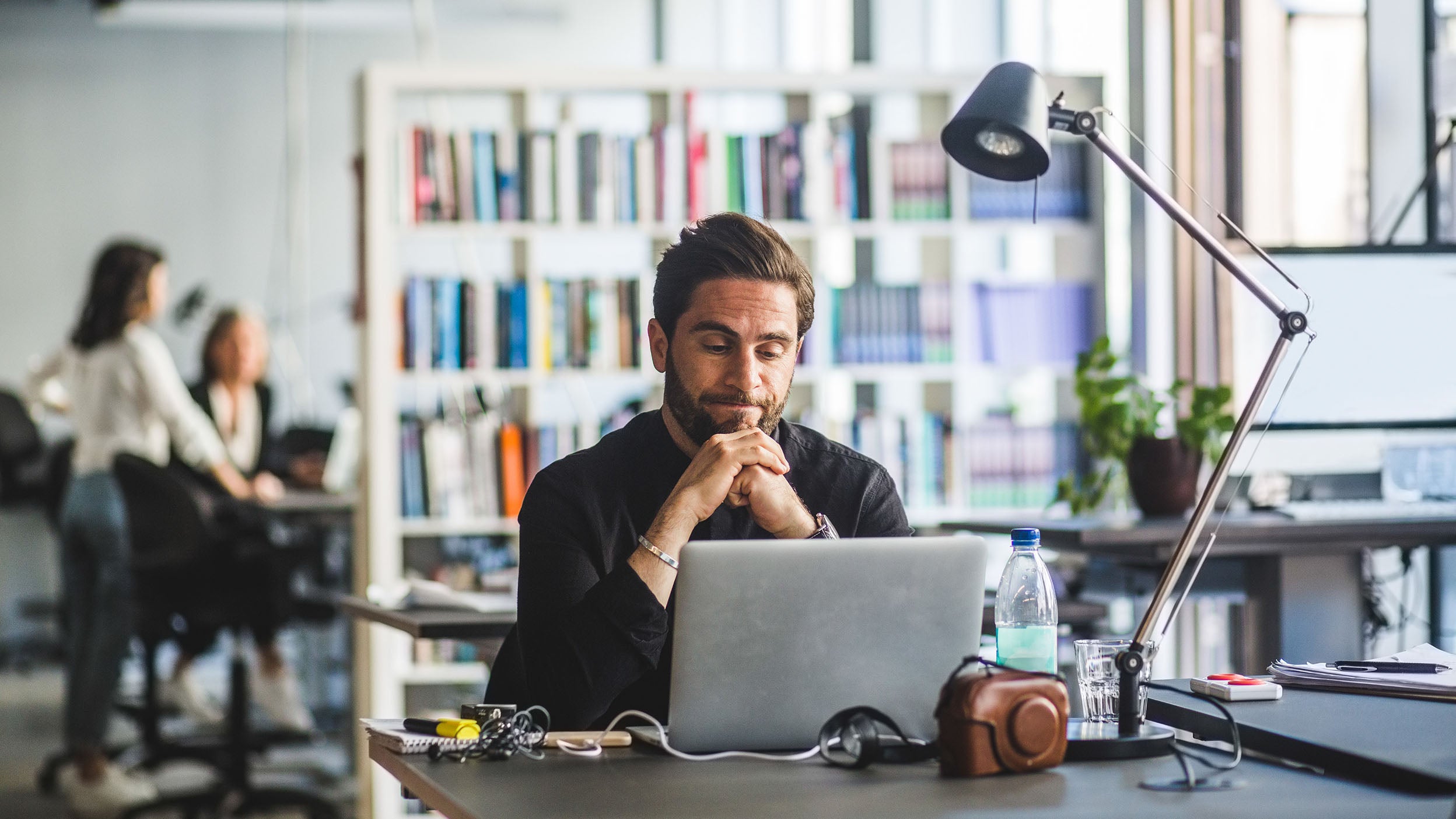 Worried businessman looking at laptop while sitting in office