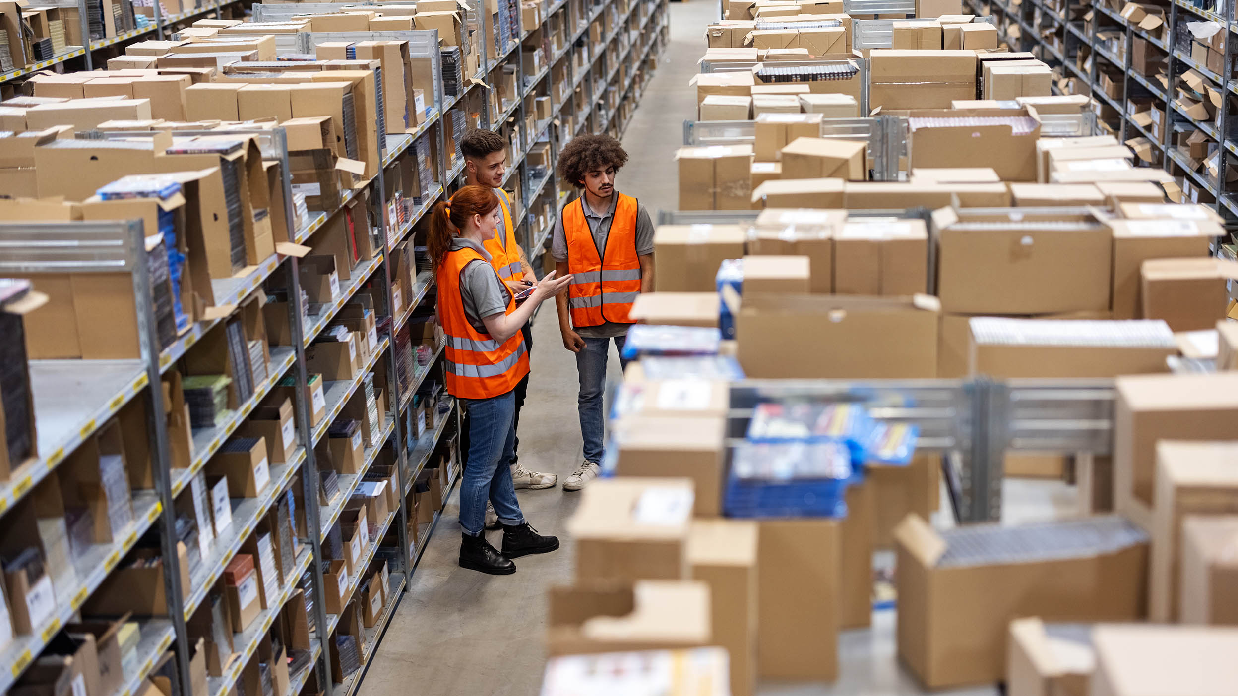 Three workers discussing inventory in a warehouse