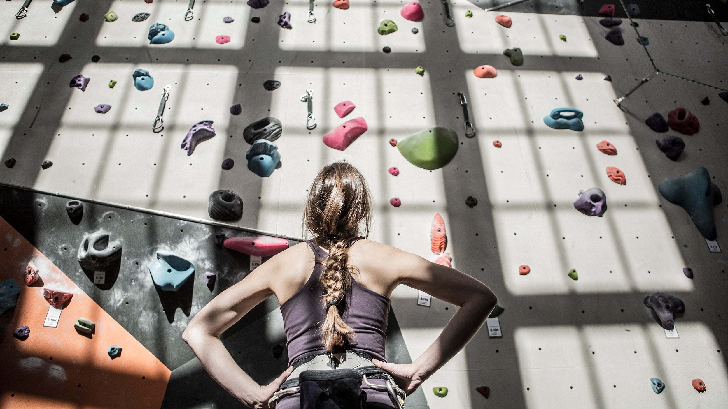 Athlete examining rock wall in gym