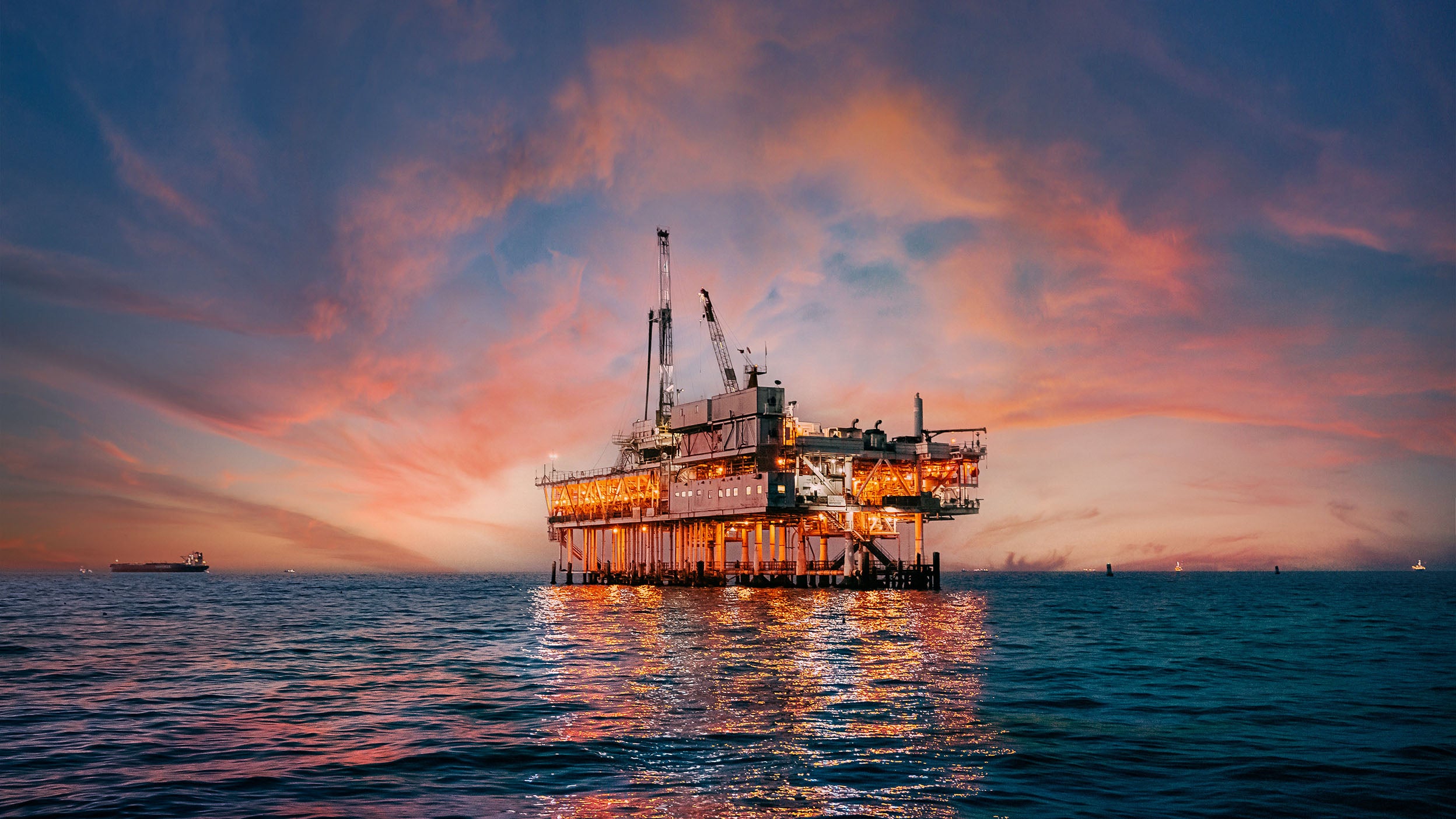 Sunset sky behind an offshore oil drilling rig off the coast of Orange County, California
