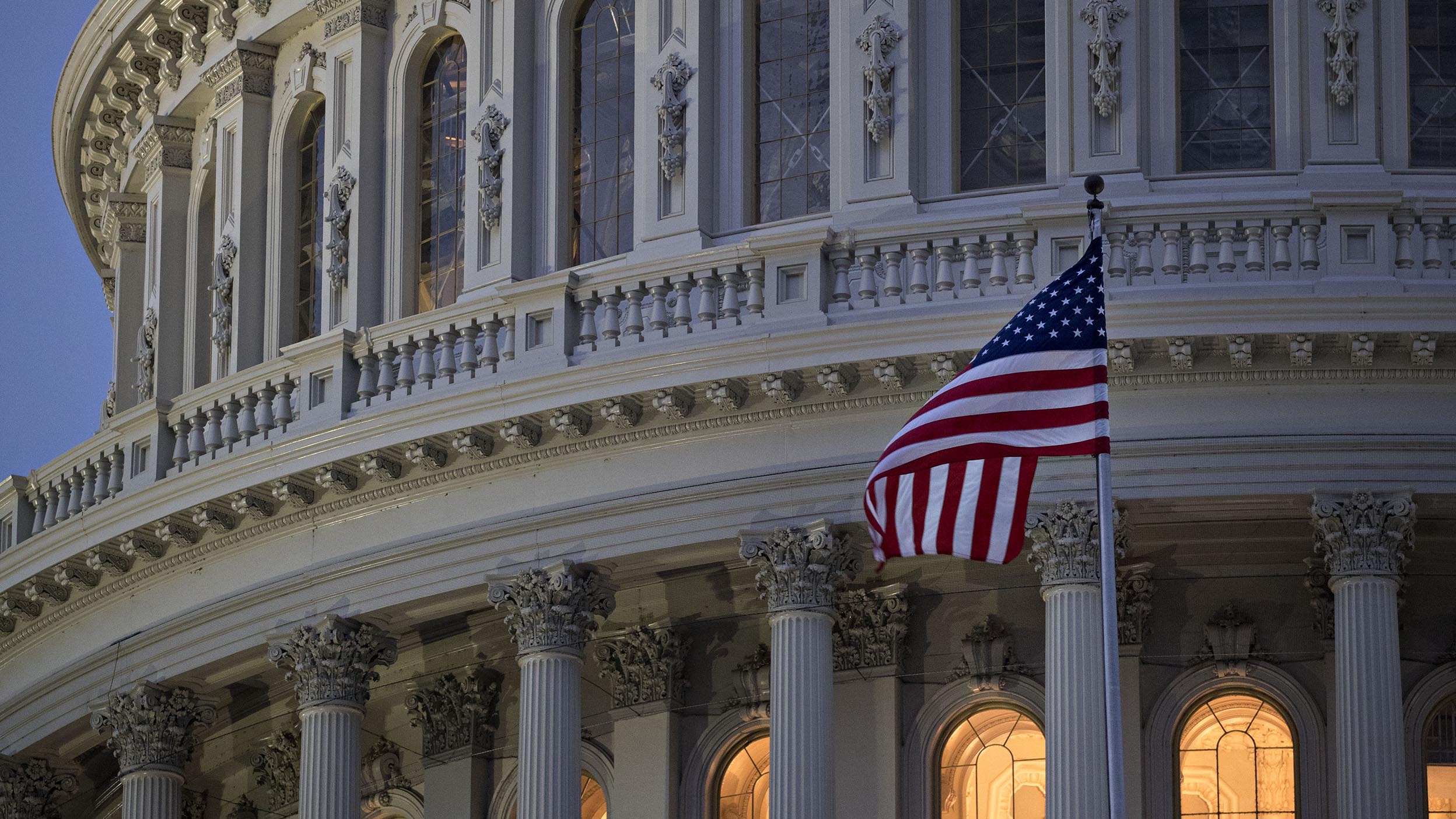 The American flag flies outside the U.S. Capitol before sunrise