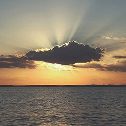 Sun%20covered%20by%20a%20cloud%20setting%20over%20the%20ocean