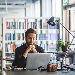 Worried%20businessman%20looking%20at%20laptop%20while%20sitting%20in%20office