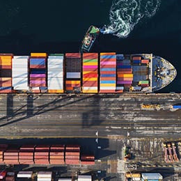 Aerial%20view%20of%20tugboats%20helping%20to%20dock%20a%20container%20ship