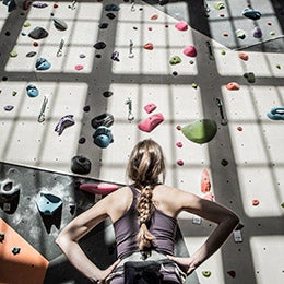 Athlete%20examining%20rock%20wall%20in%20gym