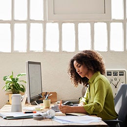 Text:%20Businesswoman%20Woman%20Writing%20While%20Working%20At%20Desk%20