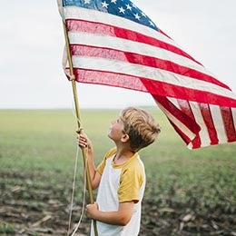 Boy%20looking%20up%20at%20large%20American%20flag
