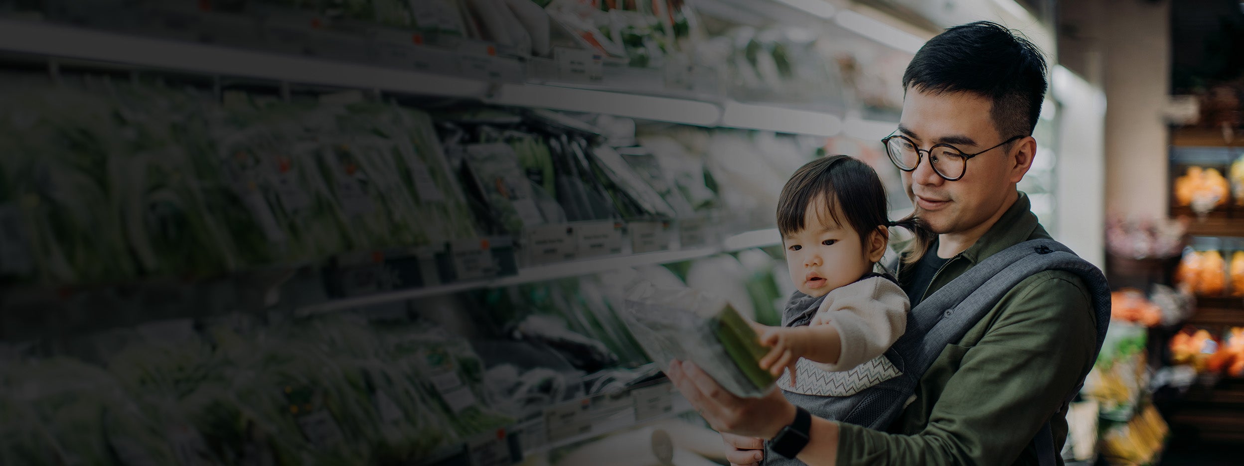 Young Asian father with cute little daughter grocery shopping for fresh organic vegetables in supermarket