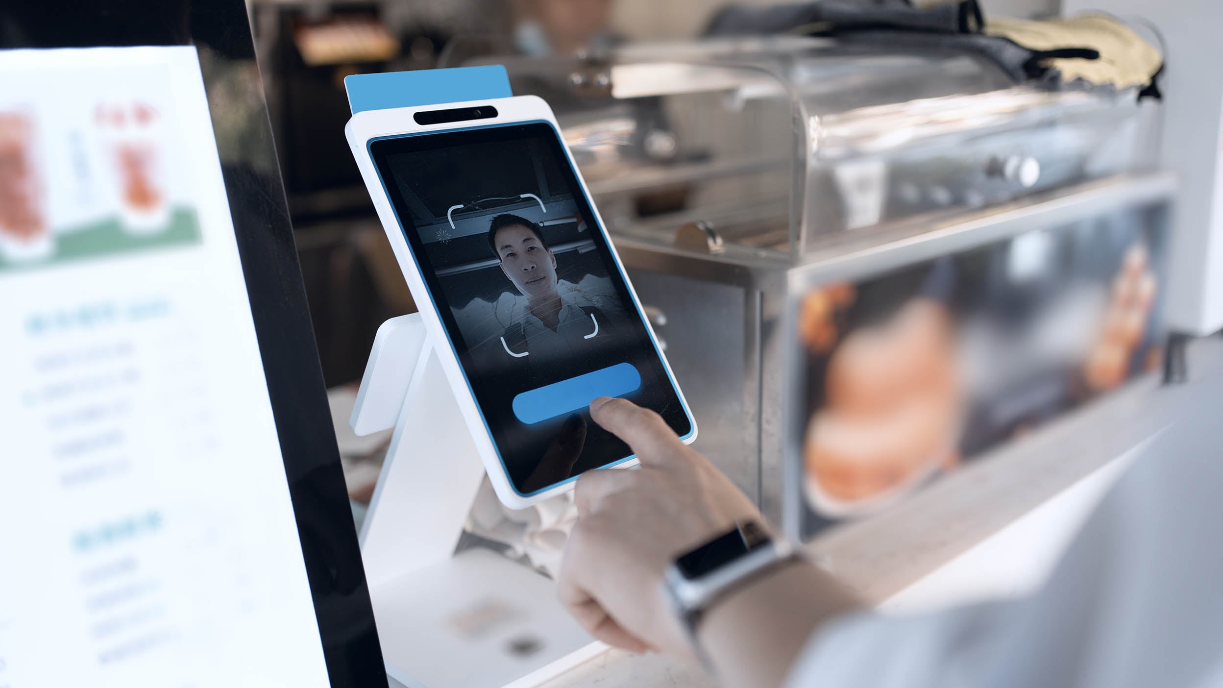 A man uses facial recognition technology, representing one of the many uses cases for biometrics that are utilized by companies within Invesco QQQ ETF.